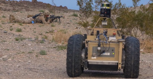 A US Marine Corps infantryman sets up a firing position while covered by an unmanned ground vehicle during field drills for DARPA's Squad X programme, held at the Air Ground Combat Center in Twentynine Palms, California.