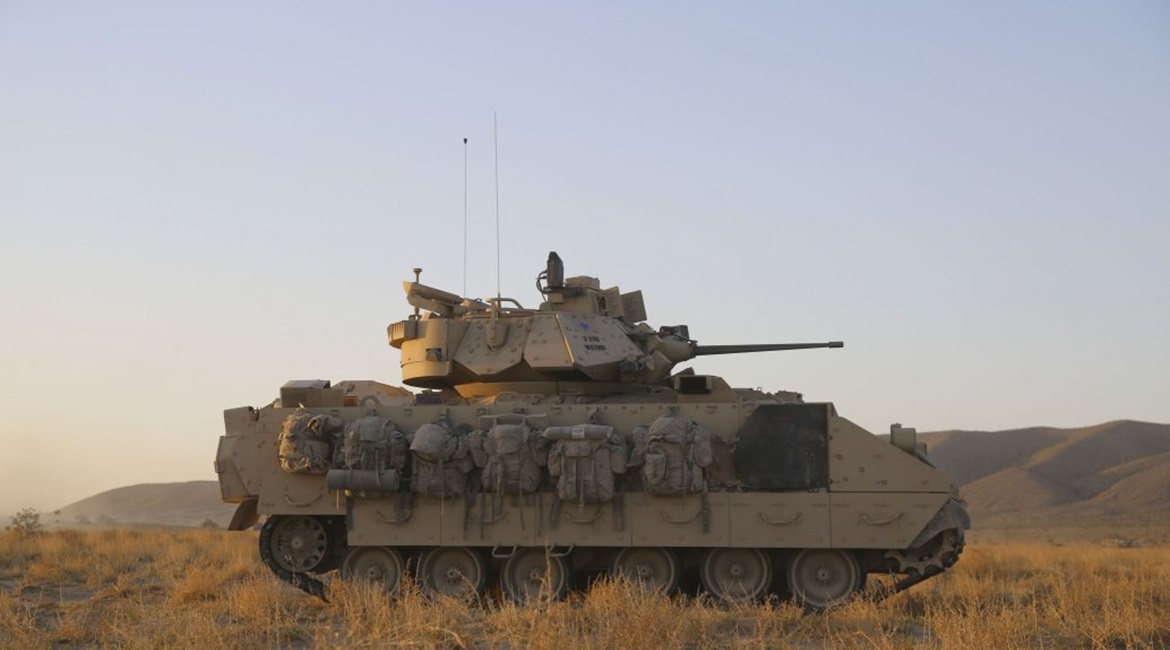 An M2A2 Bradley observes the terrain for enemy elements during training at Fort Irwin, California, in May 2018. The US Army has tasked BAE Systems with refitting two A2 Bradley vehicles with hybrid electric drives.