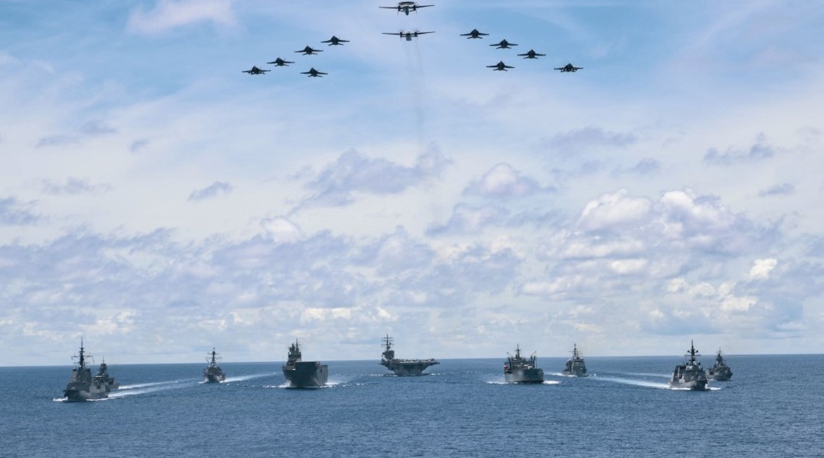 As aircraft from Carrier Air Wing 5 fly overhead, US Navy ships USS 
        
        , 
        
         and 
        
        are seen here on 21 July taking part in a trilateral passage in the Philippine Sea with Royal Australian Navy ship...