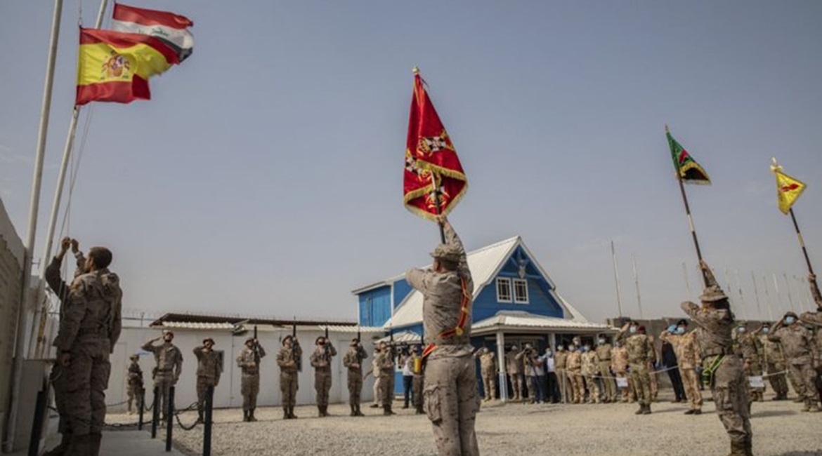 Spanish soldiers serving with the coalition lower their flag at the Besmayah Range Complex as they hand the facility over to the Iraqi Army on 25 July. CJTF-OIR attributed this and other base transfers this year to the success Iraqi forces have had aga...