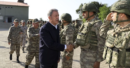 Turkish Minister of Defence Hulusi Akar greets soldiers working on the original 'Claw' operation in Hakkari, Turkey, on 4 June 2019. The operations expanded significantly a year later.