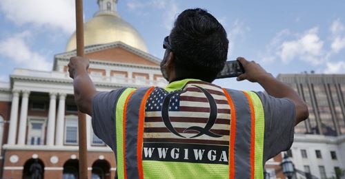 A demonstrator wearing a QAnon vest attends a 'No Mandatory Flu Shot' rally outside the State House in Boston, Massachusetts, on 30 August 2020. The acronym on his bib, WWG1WGA, is a common QAnon rallying cry, meaning 'Where We Go One, We Go All'.