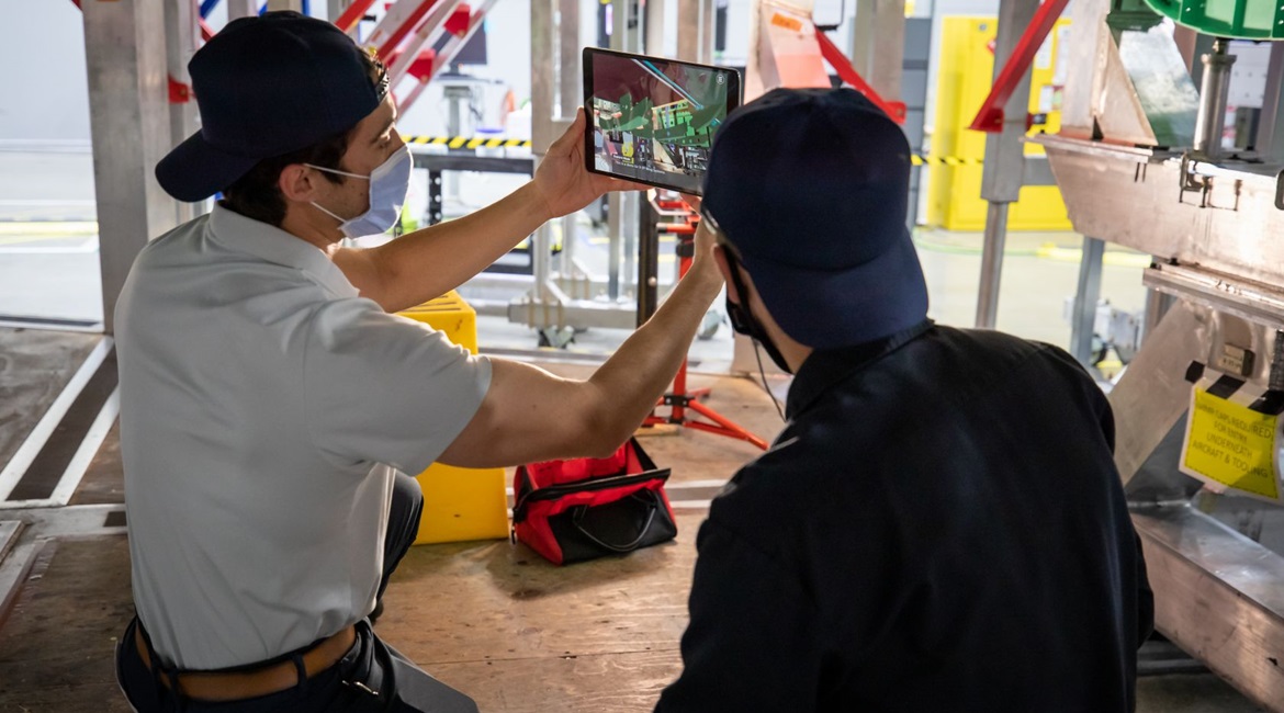 Two employees leverage augmented reality and 3D work instructions to build an air vehicle. While not demonstrative of the full scope of a digital thread (such as connecting engineering, manufacturing, and the supply chain in one virtual environment for...