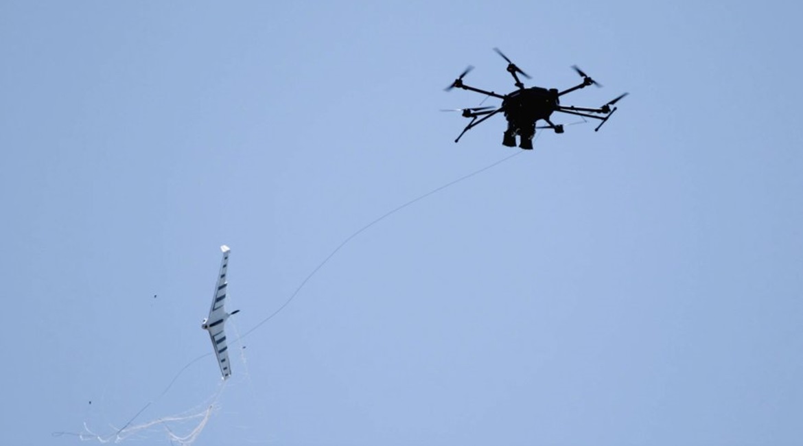 Fortem Technologies' DroneHunter UAS (right) uses its NetGun net attached to a tether to capture an enemy UAS.