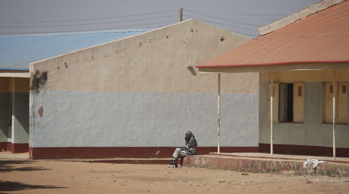A parent sits outside the Government Science Secondary School in Kankara in Nigeria's northwestern state of Katsina, where gunmen kidnapped more than 300 schoolboys on 11 December 2020.