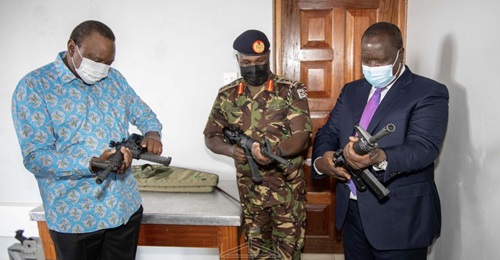President Kenyatta (left) inspects one of the rifles produced by the new Small Arms Factory.