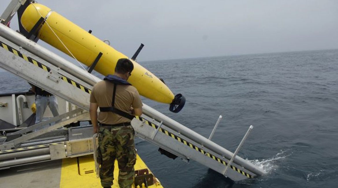A US Navy Chief Aerographer's Mate with Naval Mine and Anti-Submarine Warfare Command in Corpus Christi, Texas, monitors the deployment of a Bluefin Autonomous Underwater Vehicle (AUV).